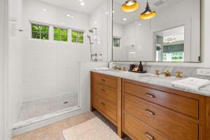 a bathroom with a shower and a sink and a mirror at Montecito Hamptons Style Gated Resort - Steps from the Beach in Montecito