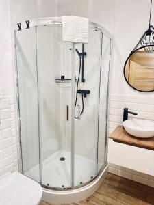 W łazience znajduje się szklana kabina prysznicowa i umywalka. w obiekcie Śpij w Kudowie pokoje gościnne w Kudowie Zdroju