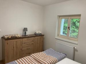 a bedroom with a bed and a dresser and a window at Vila Nikola Králiky in Králíky