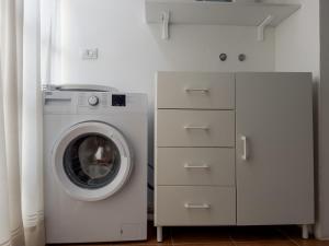 una lavatrice e un'asciugatrice in una lavanderia bianca di Host4All casa vacanze a Falconara Marittima