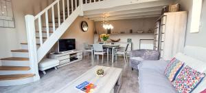 a living room with a couch and a dining room at Charmante villa entièrement rénovée, dans le centre du village in La Couarde-sur-Mer