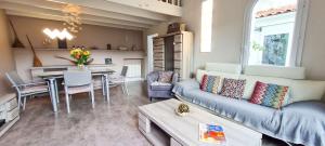un soggiorno con divano e tavolo di Charmante villa entièrement rénovée, dans le centre du village a La Couarde-sur-Mer