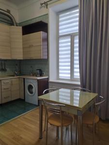 a kitchen with a table and chairs in a room at Двоповерхові апартаменти Мілена у центрі з балконом та паркінгом in Lviv