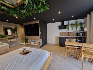 um quarto com uma cama, uma mesa e uma casa de banho em L'expérience LOVE ROOM em Saint-Jean-Bonnefonds