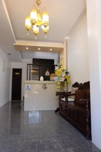un soggiorno con bar, divano e lampadario pendente di Casa Dee Leticia a Sibalom