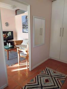 a living room with a door open to a living room at Plattekloof Treasures in Cape Town