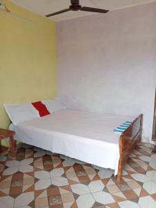 ein Schlafzimmer mit einem großen weißen Bett in einem Zimmer in der Unterkunft Poddar Retreat Managed by Wheels And Wings in Dām Dim