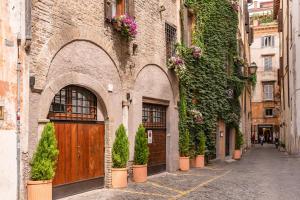a stone building with a wooden door and plants at Boutique Relais Barozzi & SPA in Rome