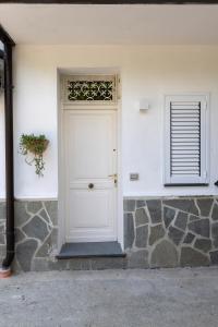 - une porte blanche sur un bâtiment blanc avec une fenêtre dans l'établissement Garden House, à Pianillo