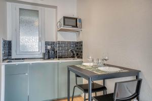 a kitchen with a table with two chairs and a microwave at Élégant studio centre Marmande Mon Petit Appart in Marmande