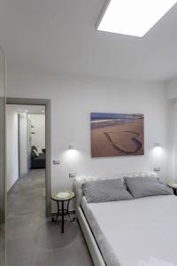 a white bedroom with a bed and a table at Garden House in Pianillo