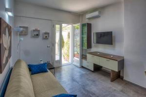 a living room with a couch and a desk and a television at Garden House in Pianillo