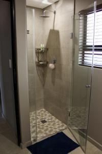 a shower with a glass door in a bathroom at Annexure A - Lovely brand new 2 bedroom flat in Groenkloof in Pretoria