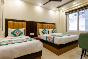 Un dormitorio con dos camas y una ventana. en Hotel Royal Rosette with free Wi-Fi near New Delhi Railway Station, en Nueva Delhi