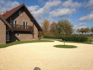 a house with a balcony and a gravel driveway at Apartments Mester in Xanten