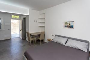 a bedroom with a bed and a table with chairs at Garden House in Pianillo