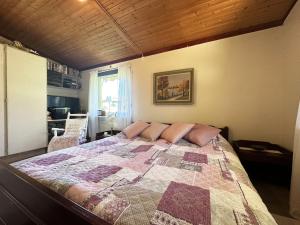 a bedroom with a large bed with a quilt on it at Cozy cottage in Kil near lake Fryken in Kil