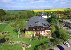 Kägsdorf的住宿－Pension Schmelzer，绿色田野上大房子的空中景色