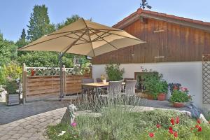 eine Terrasse mit einem Tisch und einem Sonnenschirm in der Unterkunft Alpenstern Finy, Bio-Gästehaus in Oy-Mittelberg