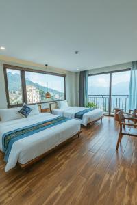 a hotel room with four beds and large windows at Sapa Yen Hotel in Sa Pa