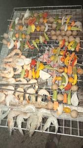 uma grelha com muitos tipos diferentes de alimentos sobre ele em Meta Homestay em Phumĭ Puŏk Chăs