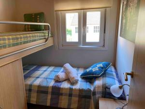 Habitación pequeña con litera y ventana en Le petit paradis, en Hío
