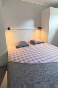 1 dormitorio con 1 cama con 2 almohadas en Terrassen 57 in Kungsberget - Your home away from home en Järbo