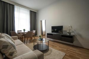 a living room with a couch and a tv and a table at Bright apartment 15 min from the city center in Vienna