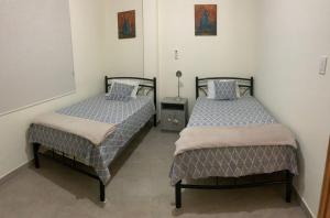 two beds sitting next to each other in a room at GARZOTA SUITE DEL ARTE 3er Piso in Guayaquil