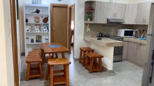 a kitchen with wooden stools and a table in it at GARZOTA SUITE DEL ARTE 3er Piso in Guayaquil