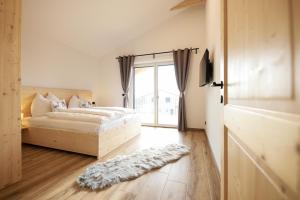 a bedroom with a bed and a sliding glass door at Sonnendörfl in Poppendorf im Burgenland