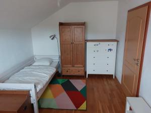 a bedroom with a bed and a dresser and a cabinet at House in beautiful suburb of Prague in Dolní Břežany