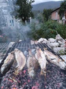 a group of fish cooking on a grill at Chveni Ezo in Ambrolauri