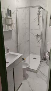 a white bathroom with a shower and a toilet at Playa Sant Adrià de Besos in Sant Adria de Besos