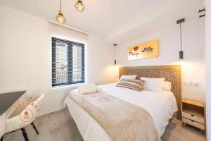 Schlafzimmer mit einem großen weißen Bett und einem Schreibtisch in der Unterkunft Stylish apartment in Malaga Centro - TCM in Málaga