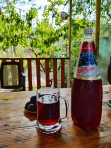 une bouteille de soda assise à côté d'un verre dans l'établissement Chveni Ezo, à Ambrolaouri