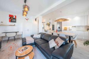 ein Wohnzimmer und eine Küche mit einem Sofa und einem Tisch in der Unterkunft Stylish apartment in Malaga Centro - TCM in Málaga