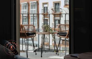 einen Tisch und Stühle auf einem Balkon mit einem Gebäude in der Unterkunft Stylish apartment in Malaga Centro - TCM in Málaga