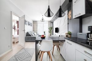 ルブリンにあるEASY RENT Apartments - CENTRUM Plac Litewski, Free parkingのテーブルと椅子のあるキッチンとリビングルーム