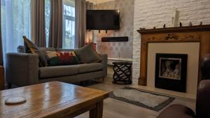a living room with a couch and a fireplace at Summerhill, Wrexham - Key Worker friendly in Wrexham