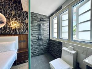 a bathroom with a shower and a bed and a sink at Kam Leng Hotel in Singapore