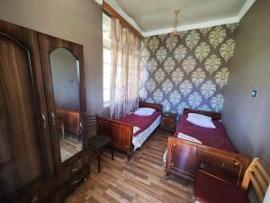 a small room with two beds and a mirror at Chveni Ezo in Ambrolauri