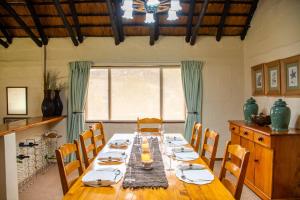 a dining room with a long table and chairs at Lolambazo Country House & Cottage - Giants Castle Drakensberg in Mahlutshini
