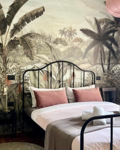 Schlafzimmer mit einem Bett und einem Wandbild von Palmen in der Unterkunft Casa del Bagatto in Treviso
