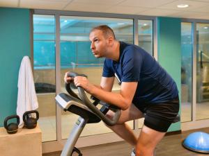 a man exercising on a treadmill in a gym at Mercure Lyon Centre Saxe Lafayette in Lyon