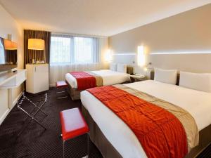 リヨンにあるメルキュール リヨン サントル サクセ ラファイエットのベッド2台とバスルームが備わるホテルルームです。