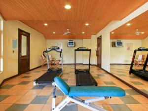 a gym with two treadmills and a chair in a room at Mercure Jaragua do Sul in Jaraguá do Sul