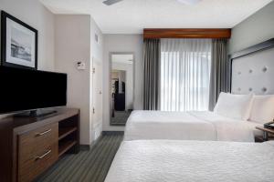a hotel room with two beds and a flat screen tv at Homewood Suites by Hilton Salt Lake City - Midvale/Sandy in Midvale