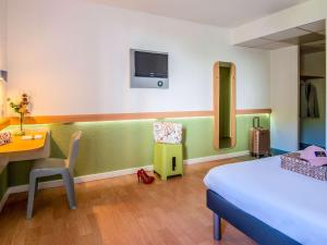 Habitación de hotel con cama, escritorio y habitación en ibis budget Bordeaux Sud, en Villenave-dʼOrnon