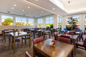 un restaurant avec des tables, des chaises et des fenêtres dans l'établissement Hilton Garden Inn Columbus/Grove City, à Grove City